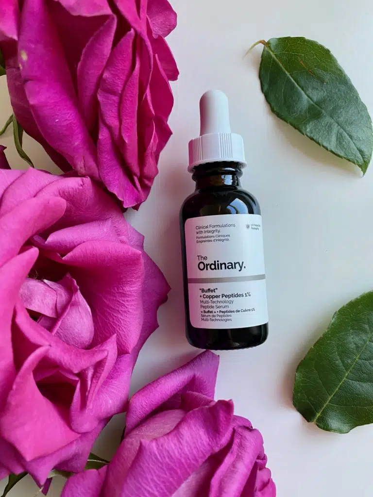 The Ordinary Buffet + Copper Peptides 1% serum next to roses